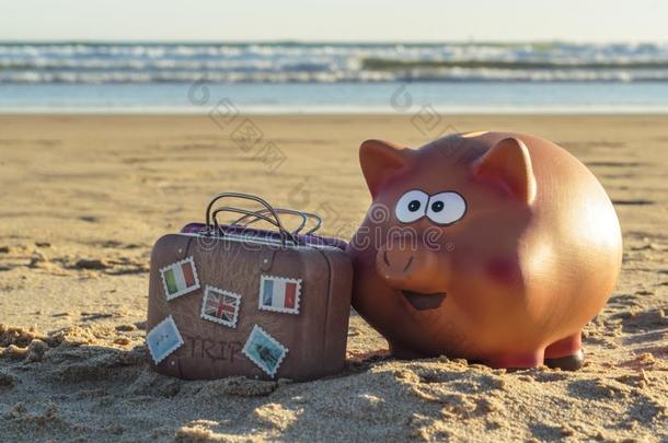 小猪银行和旅行行李向海滩