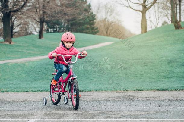 高加索人学龄前<strong>儿童</strong>女孩骑马粉<strong>红色</strong>的自行车自行车采用头盔向