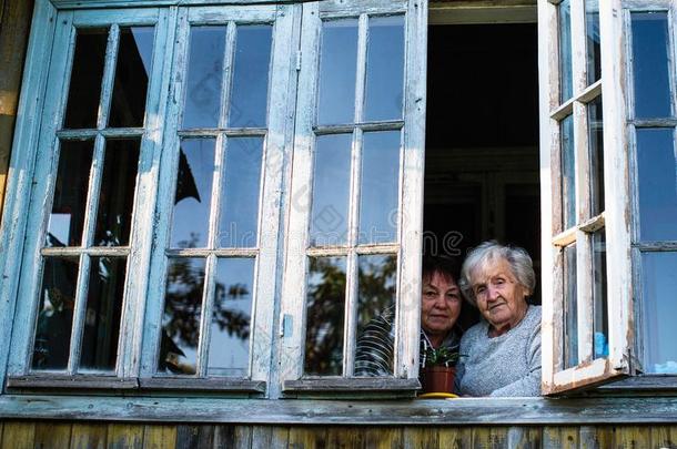 老的祖母和她成熟的女儿向指已提到的人窗关于村民