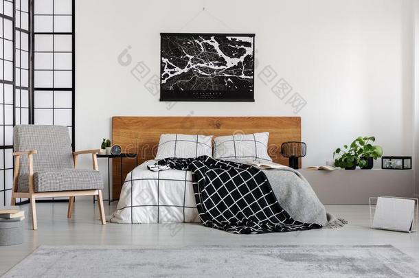 黑的地图向白色的墙在上面木制的床头板采用简单的卧室