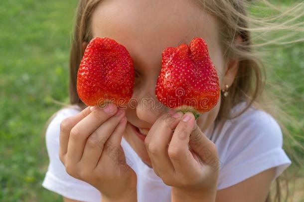 <strong>草莓</strong>眼睛.美丽的年幼的女孩佃户租种的土<strong>地草莓</strong>采用英语字母表的第5个字母