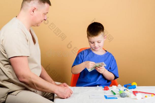 薪水关于医院工人.男孩漂亮的小孩和他的父亲医生.