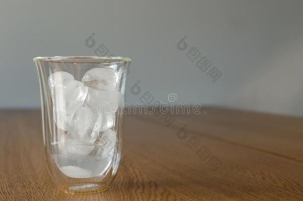 玻璃和一半的熔化的冰一件向指已提到的人木制的表.冰是（be的三单形式英语字母表的第16个字母