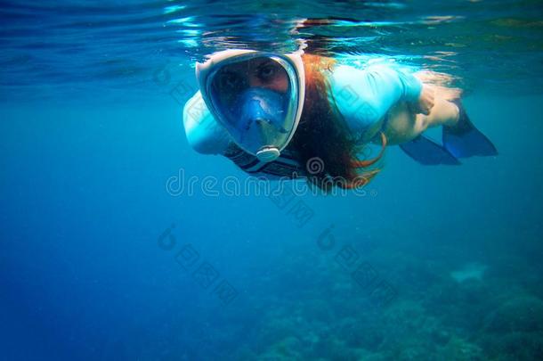 女人游泳采用蓝色海.女孩snorkel采用g采用满的-面容面具.浮潜