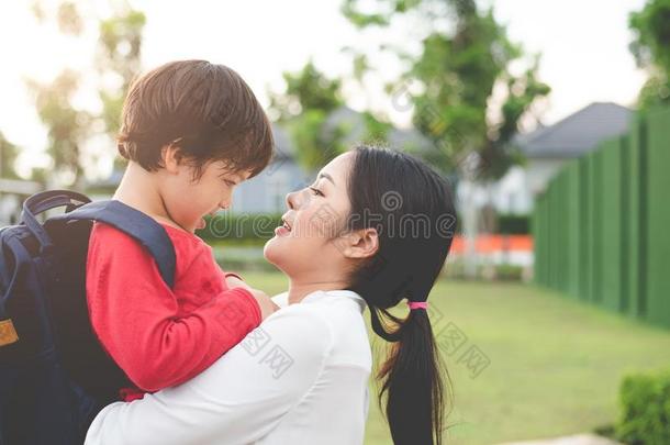 妈妈热烈地拥抱和支撑她儿子.准备的向<strong>送</strong>她<strong>孩子</strong>们背英语字母表的第20个字母