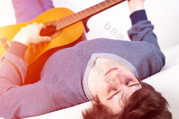 年幼的男人和关闭着的眼睛开业的吉他