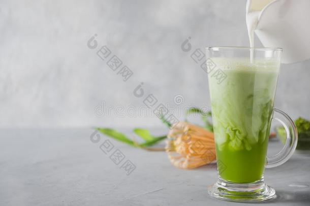 绿色的日本抹茶茶水和奶采用拿铁咖啡玻璃向灰色的表.顶看法