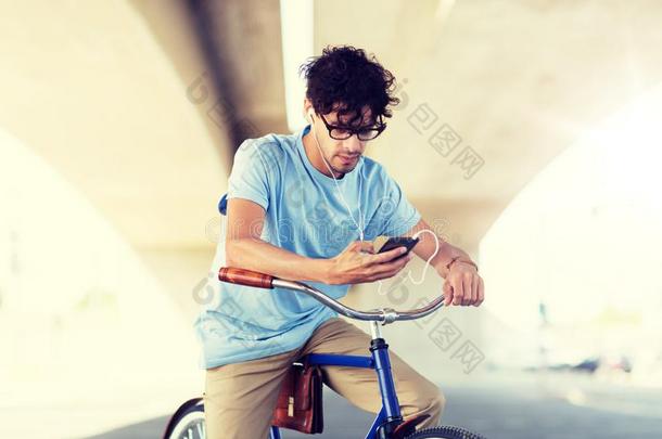 男人和智能手机和耳机向自行车