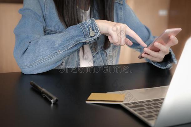 女人使用可移动的智能手机为购物在线的