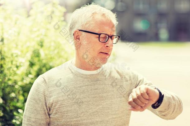 较高的男人校核时间向他的手表