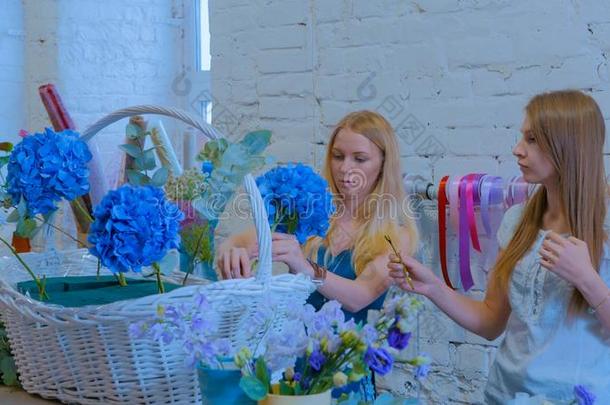两个女人花商制造大大地花的篮和花在flores花