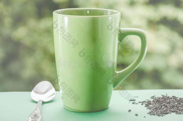 绿色的杯子关于茶水向一be一utiful绿色的b一ckground.带色彩的.