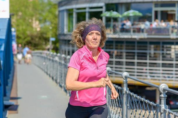 健康的适合女人慢跑锻炼者跑步通过城镇
