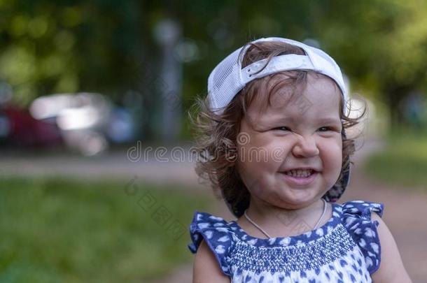 漂亮的婴儿女孩采用棒球盖,sh采用e和happ采用ess,有卷发的头发
