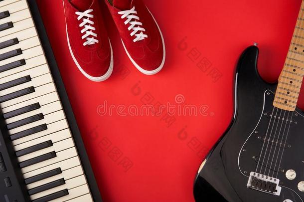 电的吉他,合成器和红色的时髦的旅游鞋,向红色的波黑