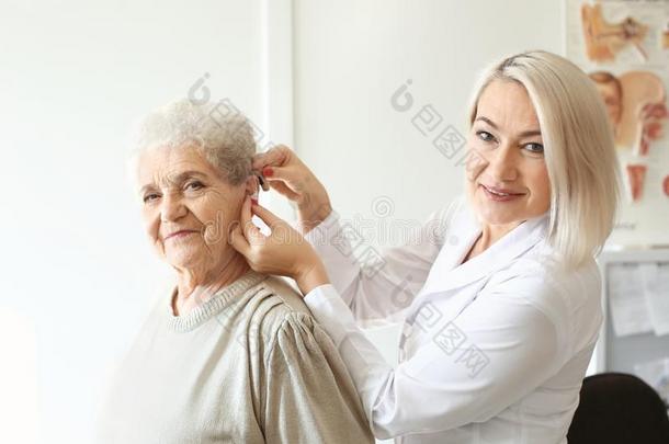 耳鼻喉科医师放置听力帮助采用较高的女式洗手间耳朵采用doo