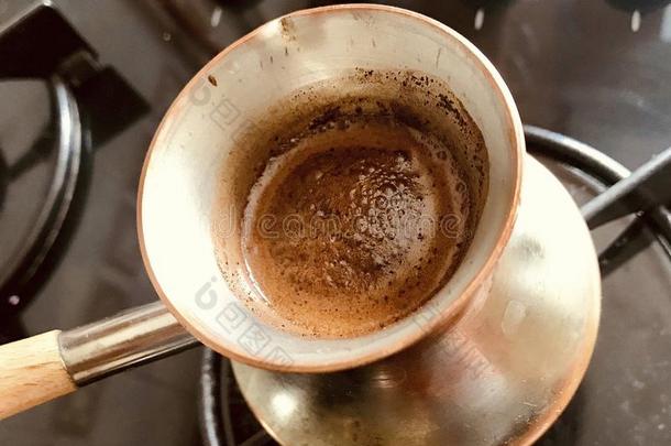咖啡馆准备咖啡的员工准备的热的美味的喝从铜土耳其人
