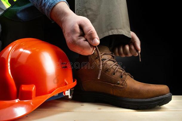 工人和头盔系带在上面皮擦靴人