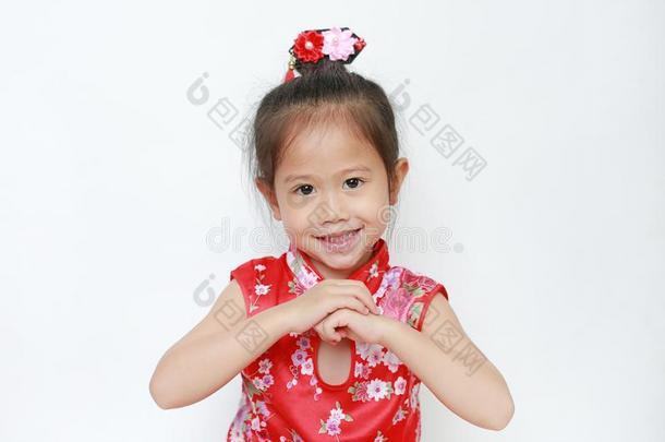 微笑的小的亚洲人小孩女孩使人疲乏的红色的旗袍和欢迎