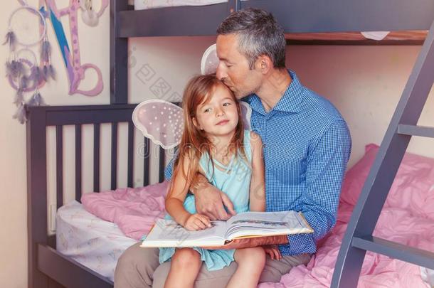 父亲爸爸和女儿女孩在家阅读书
