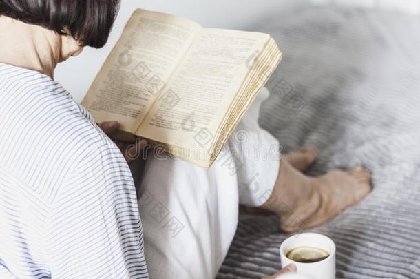 老的女人向指已提到的人床阅读老的书和杯子关于lem向茶水