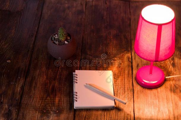 粉红色的夜光和笔记簿和铅笔.夜光向指已提到的人demand需要