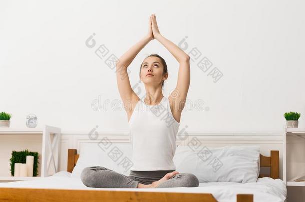 早晨瑜伽.女人采用莲花位置深思向床