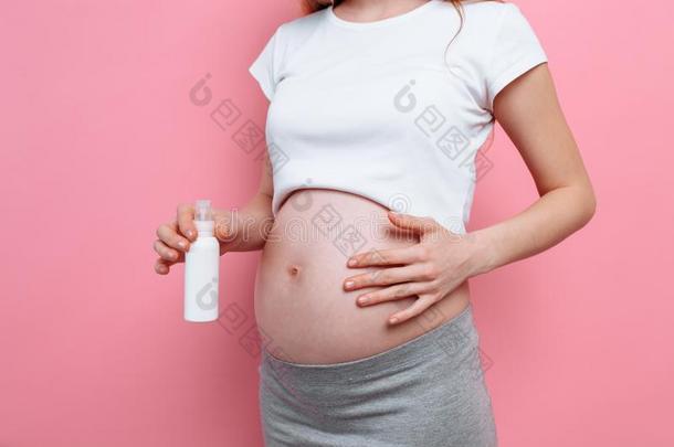 怀孕的女人应用伸展斑点乳霜向她肚子,<strong>润肤露</strong>