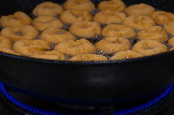 油炸圈饼油炸馅饼制造机器,手工做的,油炸甜的和美味的
