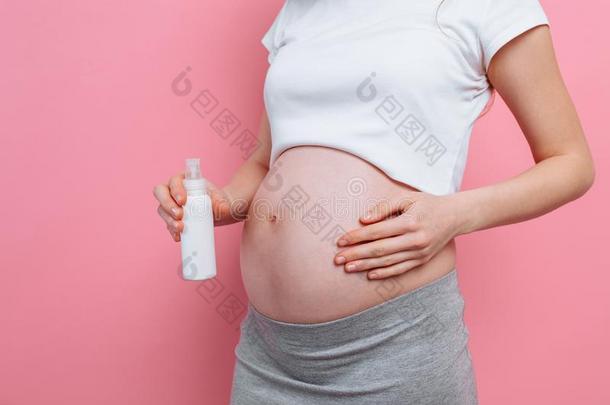 怀孕的女人应用伸展斑点乳霜向她肚子,<strong>润肤露</strong>
