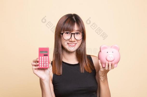 亚洲人女人和计算器和小猪银行