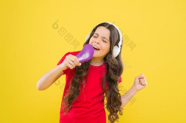 卡拉OK星.漂亮的小的女孩假装唱歌卡拉OK向yellow黄色