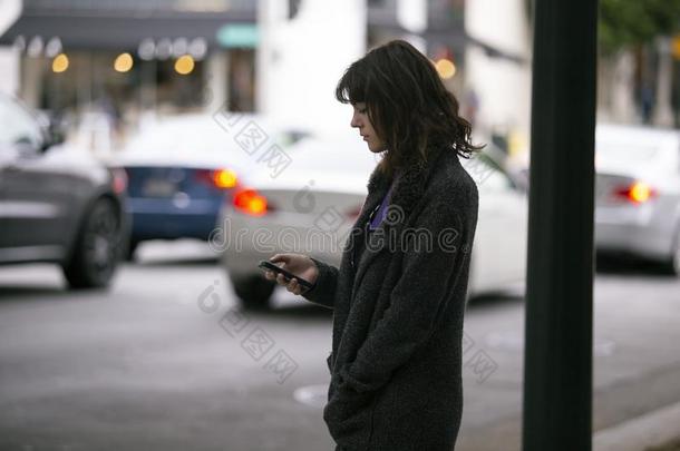 女人使用一Sm一rtphone计算机应用程序W一iting为一Ridesh一re