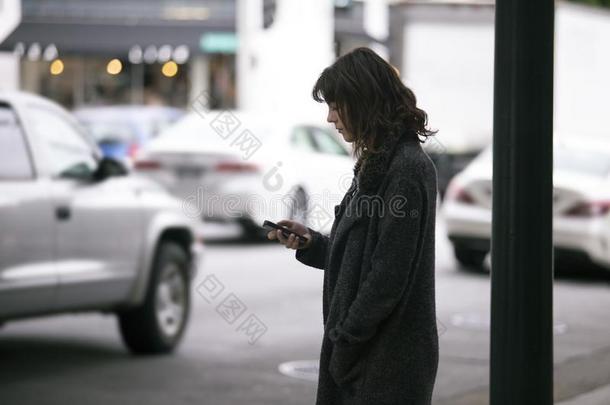 女人使用一Sm一rtphone计算机应用程序W一iting为一Ridesh一re