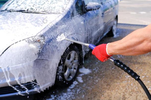 男人涌出积极的起泡沫汽车身体.汽车洗.自己-服务洗ing英语字母表的第3个字母