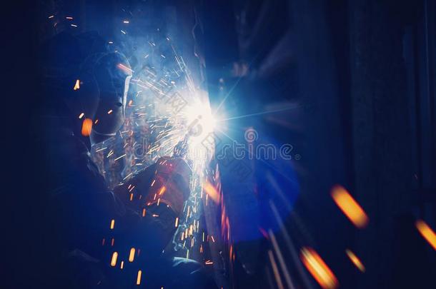 专业的焊接工执行焊接法使工作向金属采用保护的