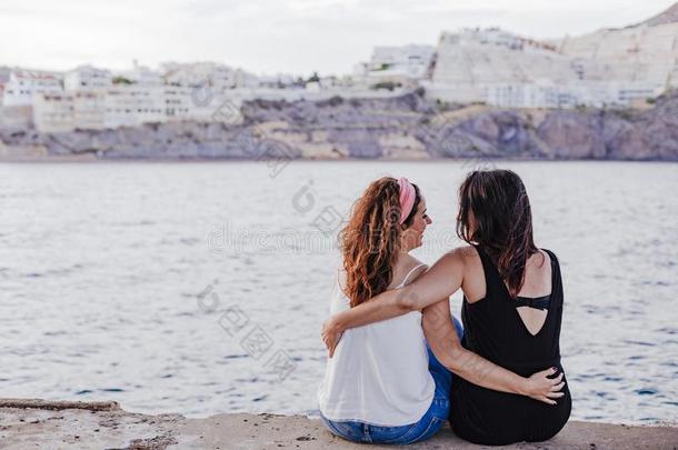 两个女人朋友一次在旁边指已提到的<strong>人海</strong>滩热烈地拥抱.生活方式康塞普