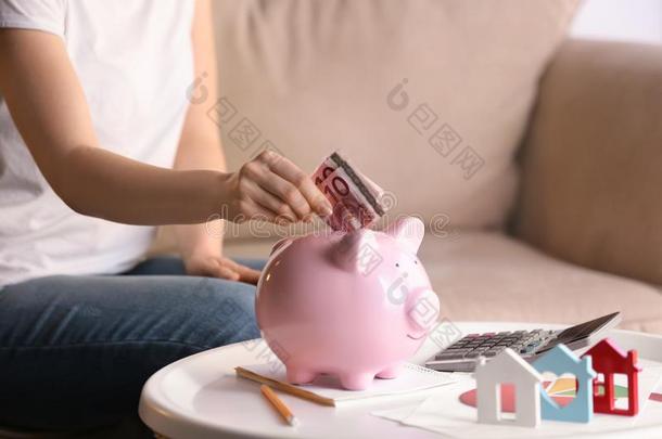 女人放置钱进入中小猪银行在家