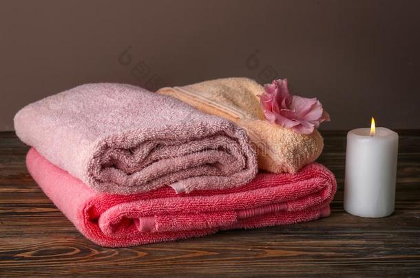 富有色彩的干净的毛巾和燃烧的c和le向木制的表