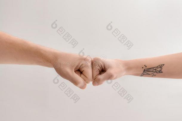 男人和女人制造拳碰撞手势向光背景