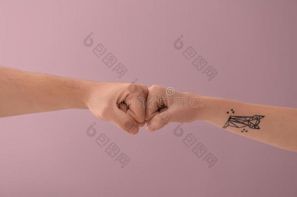 男人和女人制造拳碰撞手势向颜色背景
