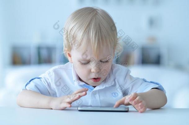 肖像关于男孩和智能手机演奏指已提到的人游戏在家
