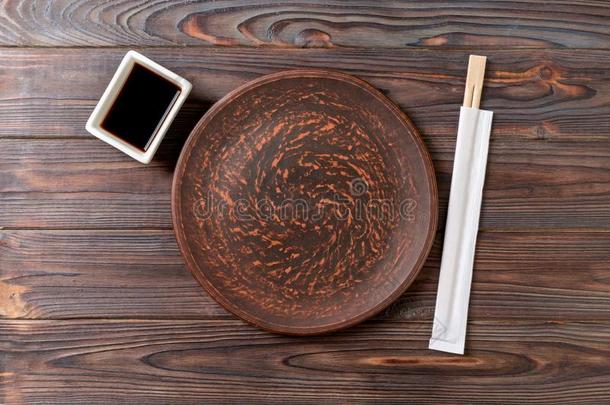 空的黑暗的酿酒的圆形的<strong>盘子</strong>和<strong>筷子</strong>为寿司向木材