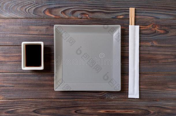 空的灰色正方形盘子和筷子为寿司向木制的背