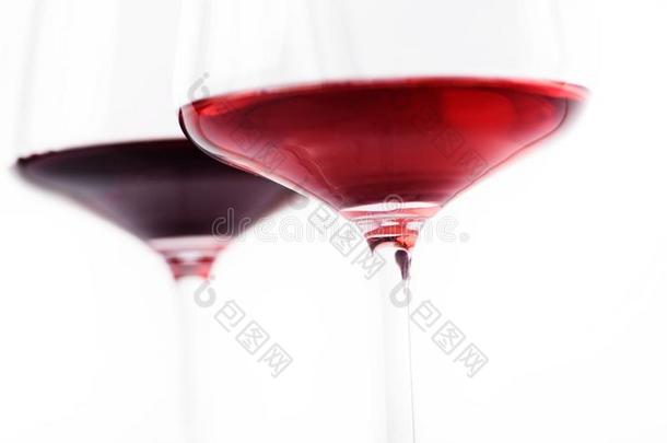 特写镜头关于两个玻璃关于红色的和玫瑰葡萄酒越过白色的背景