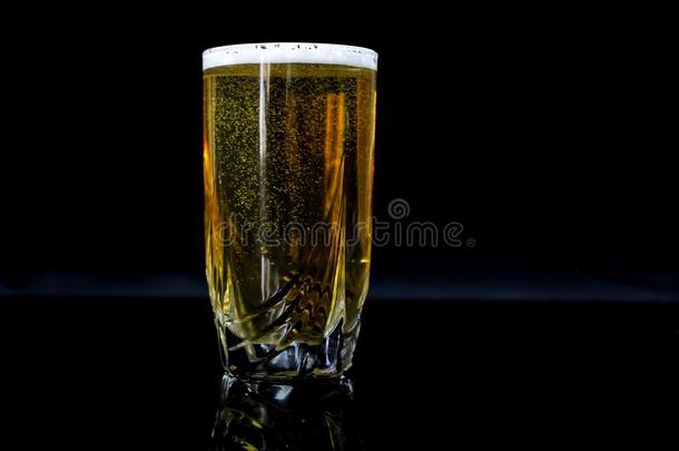 玻璃和啤酒,黑的背景,黄色的啤酒