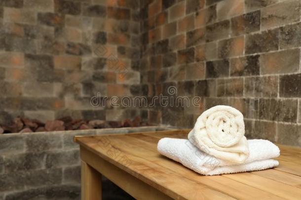 白色的毛巾向木制的长凳采用盐桑拿浴室