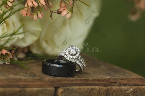 钻石新婚的婚礼带和订婚戒指放置在旁边玫瑰布河