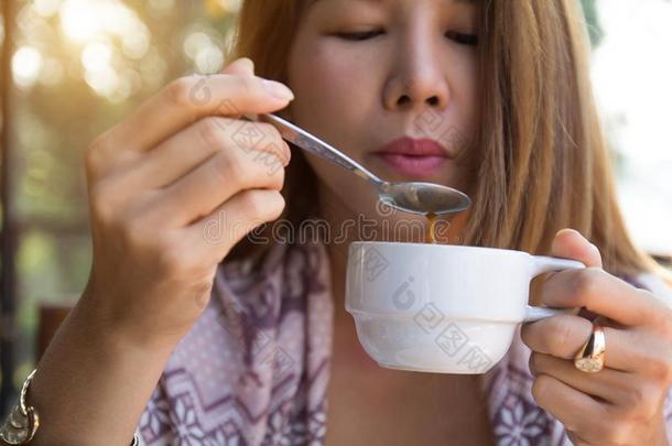 年幼的女人佃户租种的土地喝饮料咖啡豆使用勺吹<strong>风</strong>热的cofferdam围堰