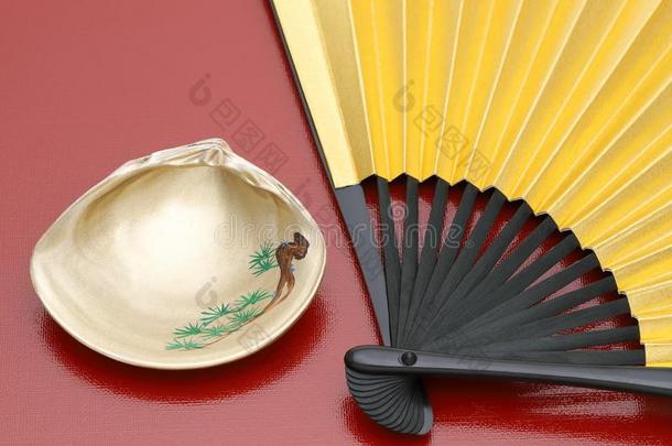 日本人金色的可折叠的扇子和海中软体动物的壳